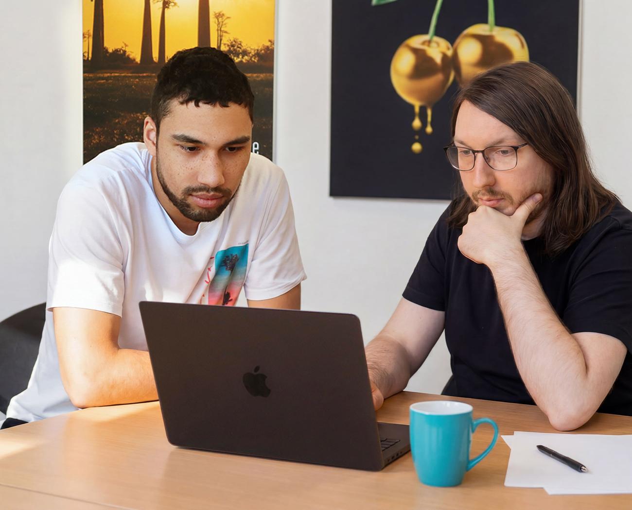 Social media uitbesteden | Twee mannen bespreken hun opties achter laptop