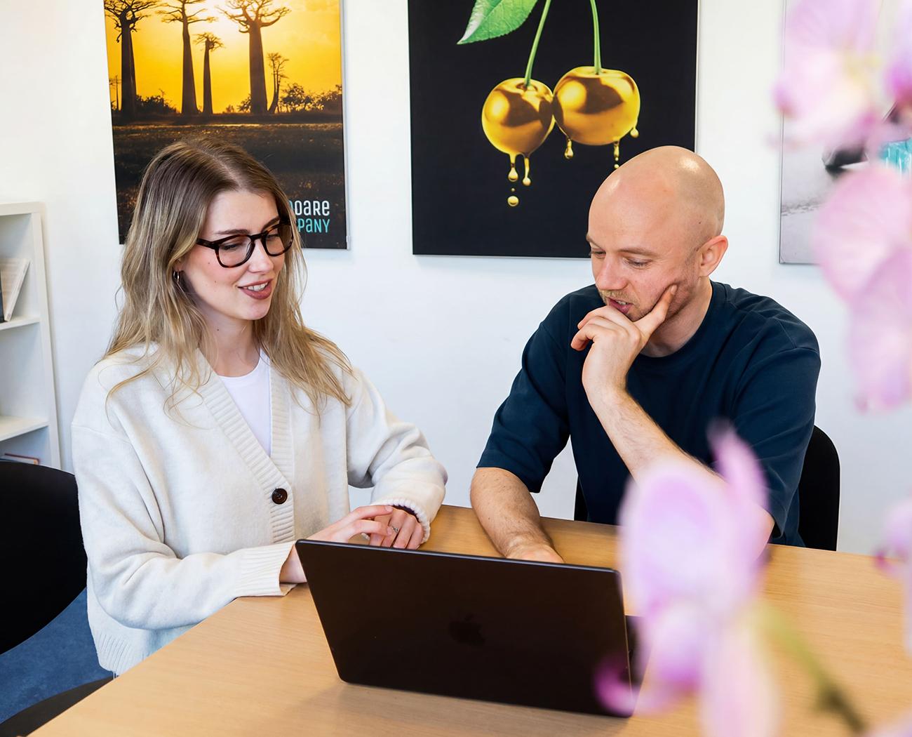 SEO Outsourcing | Two people discussing how SEO works while sitting at their laptops