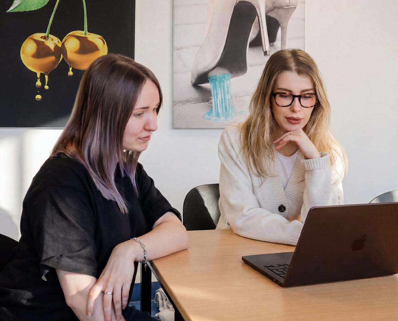 SEO Outsourcing | Two women discussing SEO behind a laptop