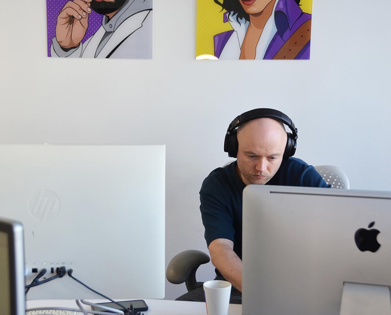 Website maintenance | man wearing headphones working at a computer